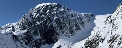 Snow-covered mountain peak under a clear sky, no people or equipment visible.