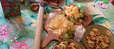 A table with various foods, including meat, cheese, pastries, and an ice pick.