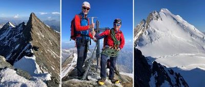 Two people with helmets and climbing gear are standing on a snow-covered mountain peak.
