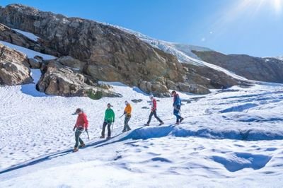 Eine Gruppe von fünf Personen geht über den Gletscher