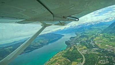 View from the skydiving plane over Reichenbach towards Lake Thun and the Swiss Alps in summer.