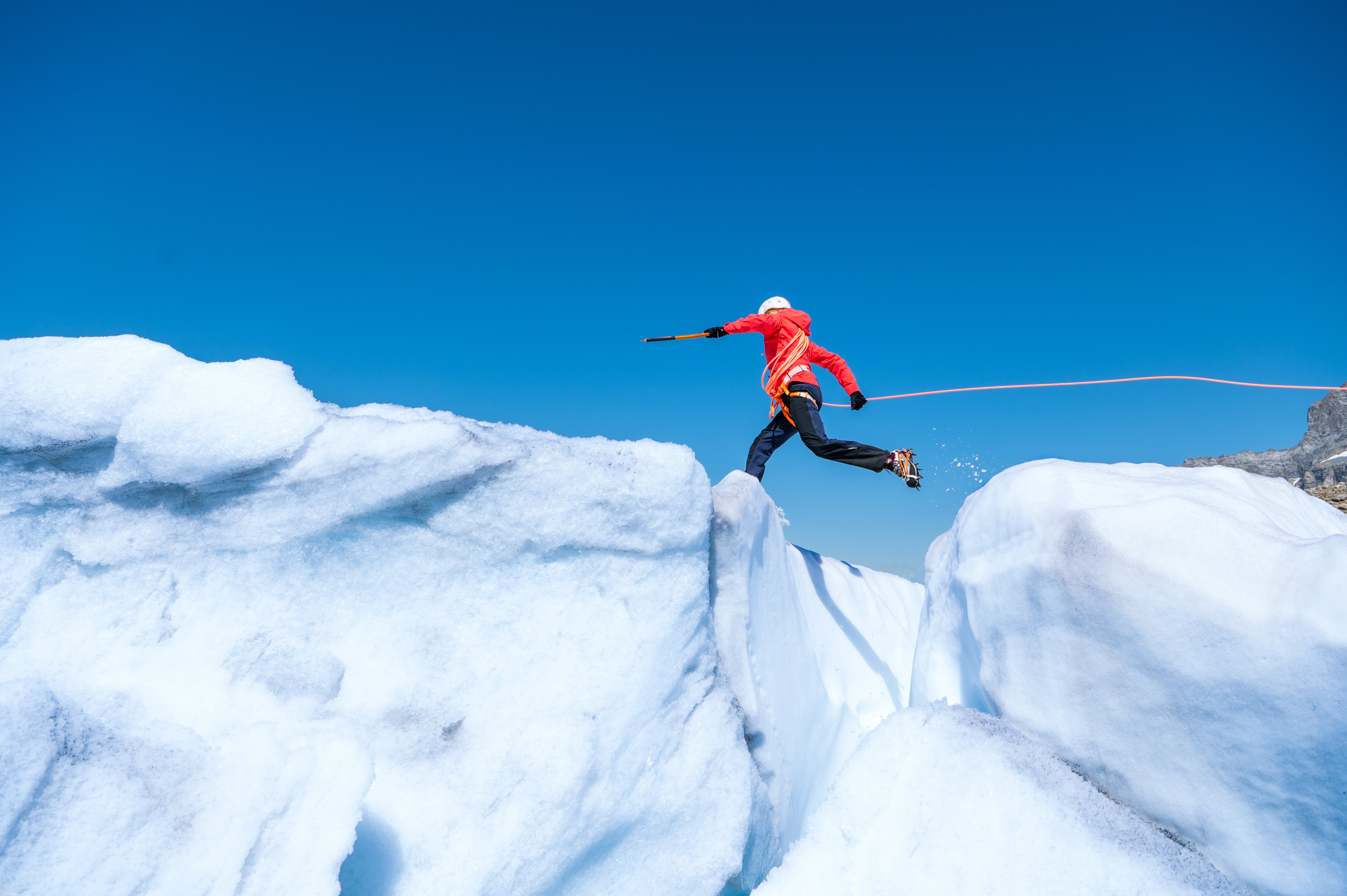 Mountaineer jumps over crevasse