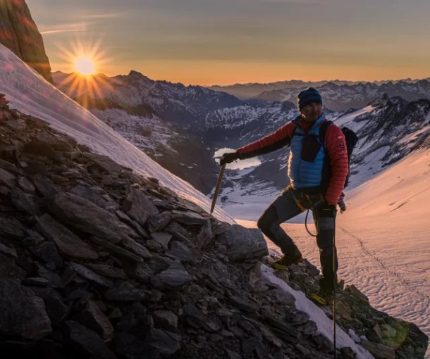 Mountain guide at Oberaarhorn with sunrise in the background