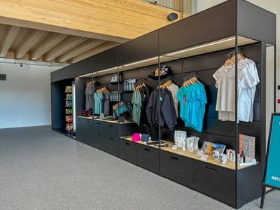 현대적인 소매 공간에 의류, 헬멧 및 액세서리가 전시된 상품 전시입니다.