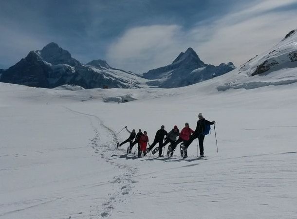 Group of snowshoe hikers at Bachalpsee on the way up to Faulhorn.