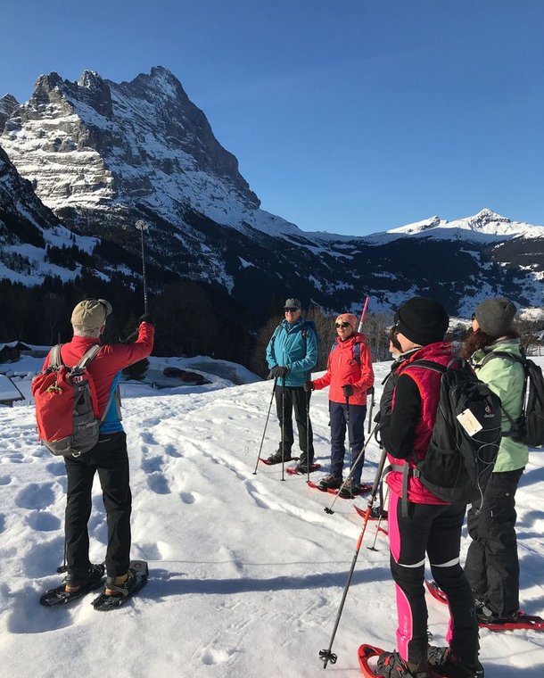 Group of snowshoe hikers above Grindelwald with a view of the Eiger.