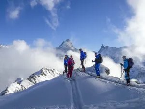 Ski tourers ascending with the Schreckhorn in the background.