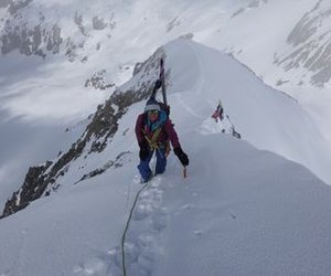 Skitourengänger mit aufgebundenen Ski auf Grat