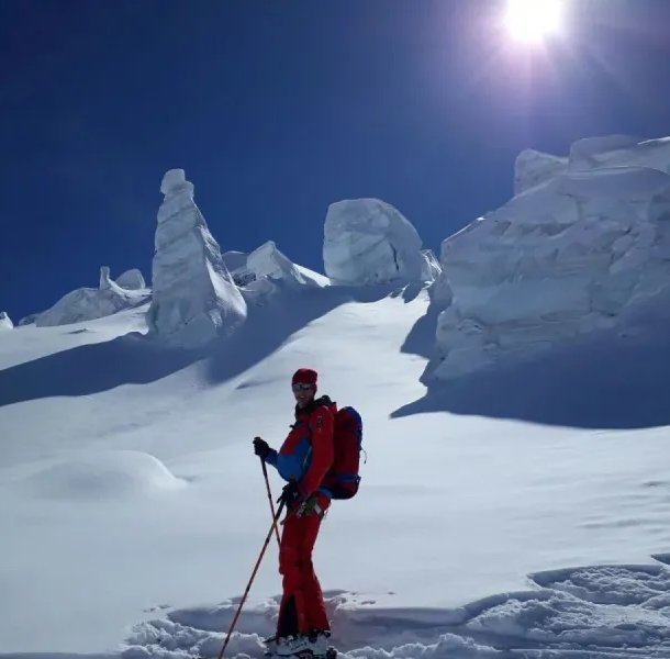 Ski tourers on the glacier with ice blocks in the background.