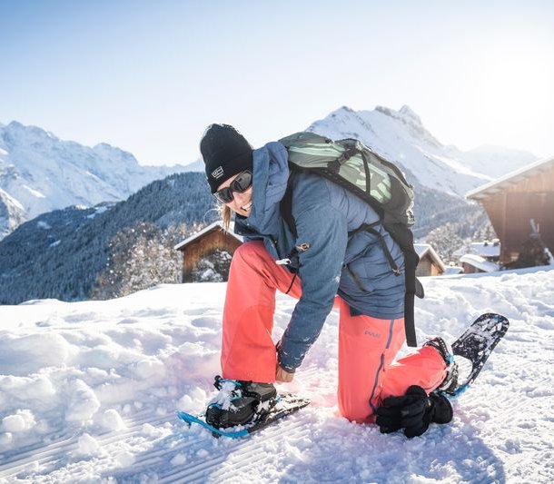 Person zieht Schneeschuhe an