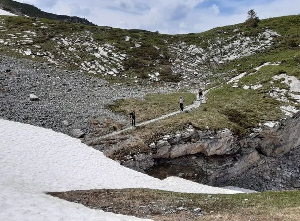 Hiker standing in front of a snowfield.