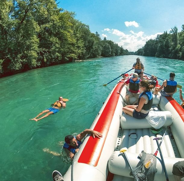 People on a raft during the Aare river cruise, some participants let themselves drift next to the boat