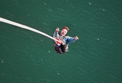 Close-up of a person bungee jumping over the water