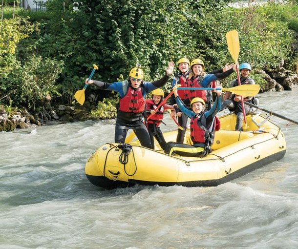 Gruppe beim Family Rafting lachend und posierend auf der Lütschine.
