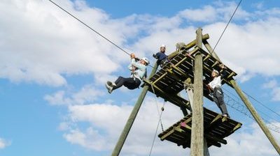 Several people are standing on a wooden platform in the Rigi rope park