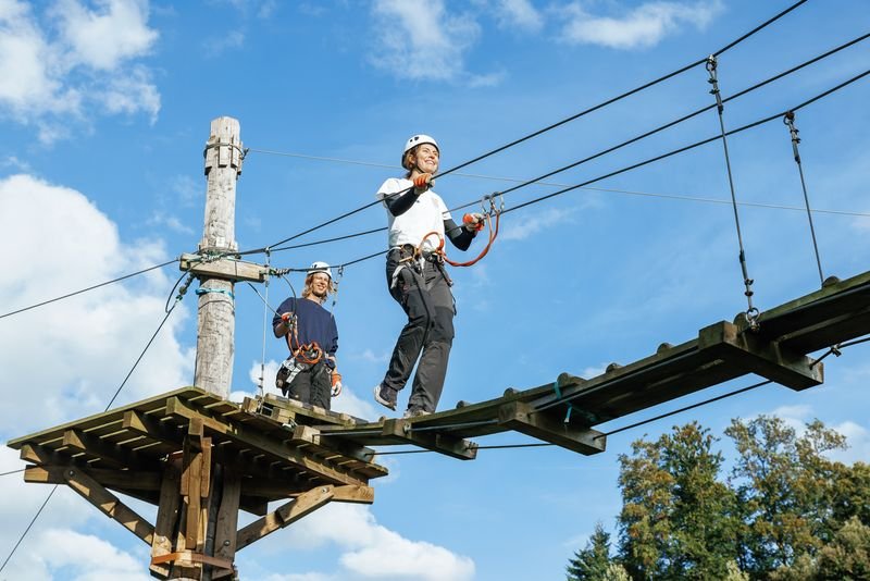 Person walks across a wooden bridge in the Rigi Rope Park