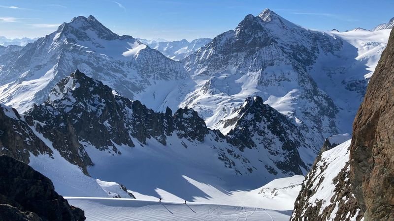 Snow-covered mountain landscape with high peaks and deep valley, no people or equipment visible.